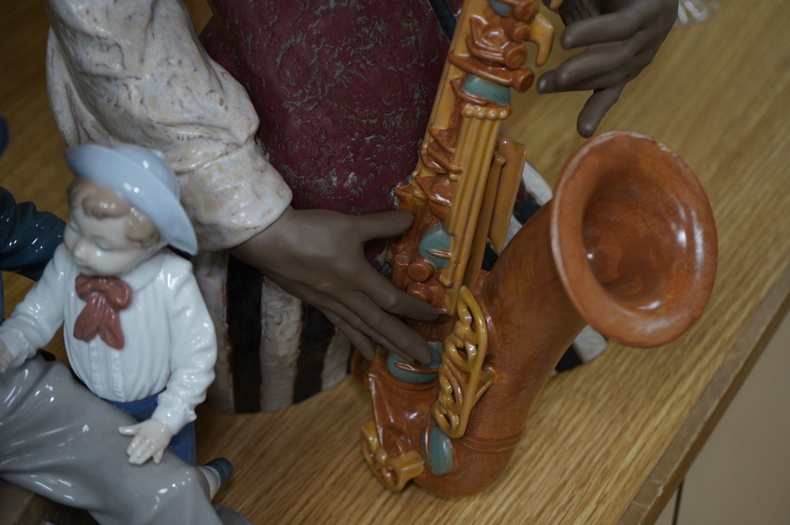 A Lladro figure ‘Playing the Blues’, 63cm high and a ‘Tall Yarn’ figure group of a fisherman and a boy. Condition - fisherman lacking the ship in his hand, otherwise good
